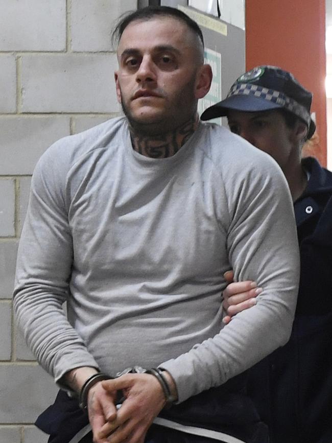 Yusuf Nazlioglu is escorted from Kogarah Police Station in August, 2018, after Hawi was shot. Picture: Gordon McComiskie