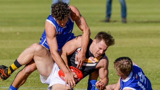 Brighton’s Nigel Osborn is tackled by St Peter’s Old Scholars opponents during a game last month. Picture: Brenton Edwards