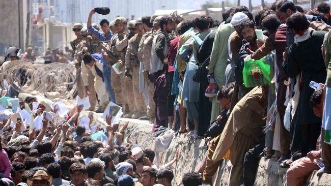 Afghans struggle to show their credentials to flee the country outside the Hamid Karzai International Airport, in Kabul, Afghanistan, on 26 August 2021.