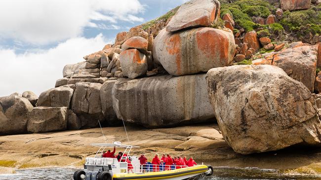 Granite rocks tower over passengers on board a Pennicott Wilderness Journeys boat trip at Wilsons Prom. Picture: Supplied