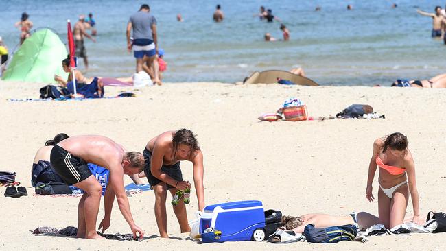 Hot weather in Melbourne. Sunbathers cool off with some drinks at South Melbourne beach. Picture: Ian Currie