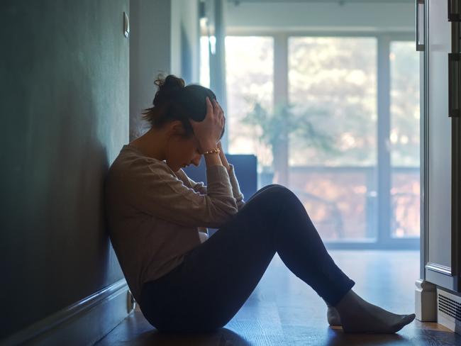 istock generic:  woman, abuse, DV, domestic violence, harassment, sexual harassment.   Sad Young Woman Sitting on the Floor In the Hallway of Her Appartment, Covering Face with Hands. Atmosphere of Depression, Trouble in Relationship, Death in the Family. Dramatic Bad News Moment . Picture: istock