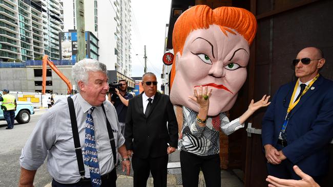 Ron Boswell, left, passes a protester wearing a Pauline Hanson mask last week. Picture: AAP