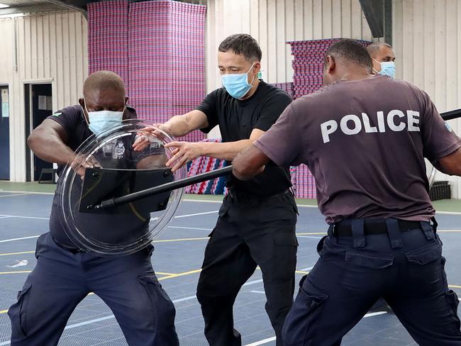 A China Police Liason Team officer (centre) trains local Solmon Islands officers in unarmed combat skills, advanced usage of long sticks, round shields, tactical batons, T-shape baton, handcuffs, basic rifle tactics and crowd control.