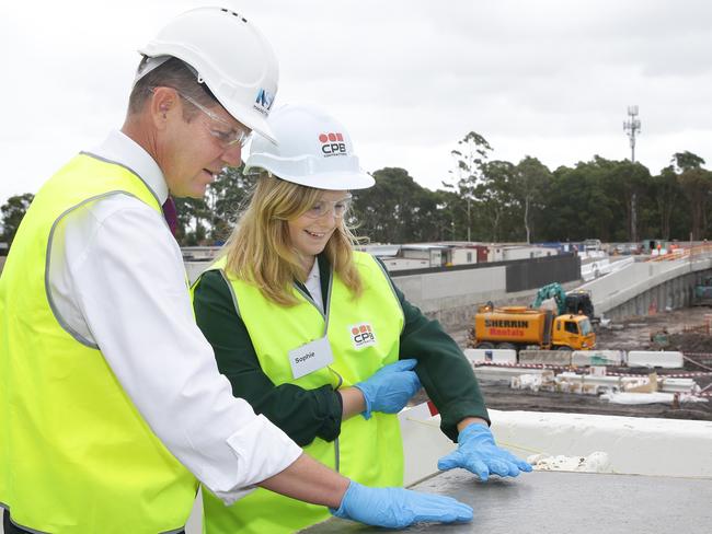 NSW Premier Mike Baird, and Frenchs Forest High student Sophie Jukes leave their handprints in the concrete at the new Northern Beaches Hospital site.