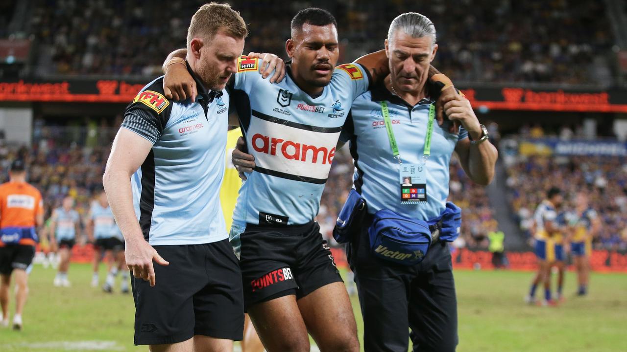 Sione Katoa of the Sharks is assisted from the field after sustaining a knee injury.