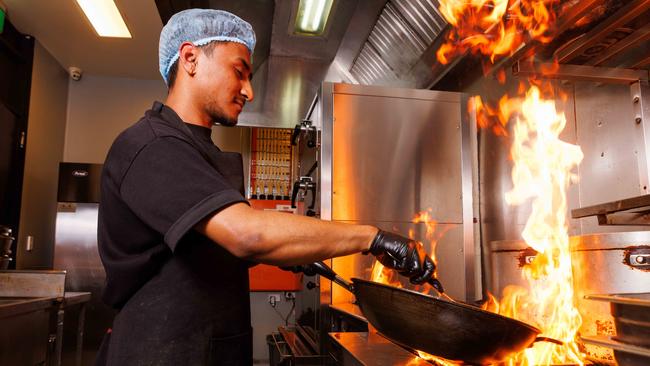 Cook Ashim Bakhunchhe whips up a feed on a gas stove at Kickin’Inn at Zetland. Picture: David Swift