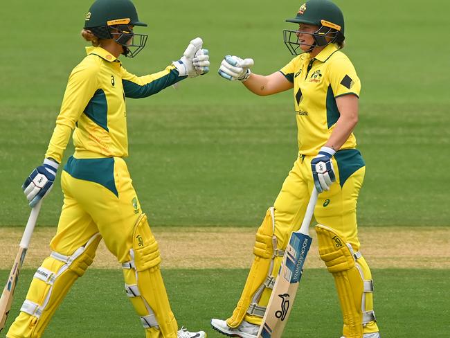 BRISBANE, AUSTRALIA - OCTOBER 08: Phoebe Litchfield and  Alyssa Healy of Australia bump gloves during game one of the One Day International series between Australia and the West Indies at Allan Border Field on October 08, 2023 in Brisbane, Australia. (Photo by Albert Perez/Getty Images)