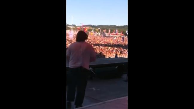 Crowd help artist with Tourette's sing his songs at a festival