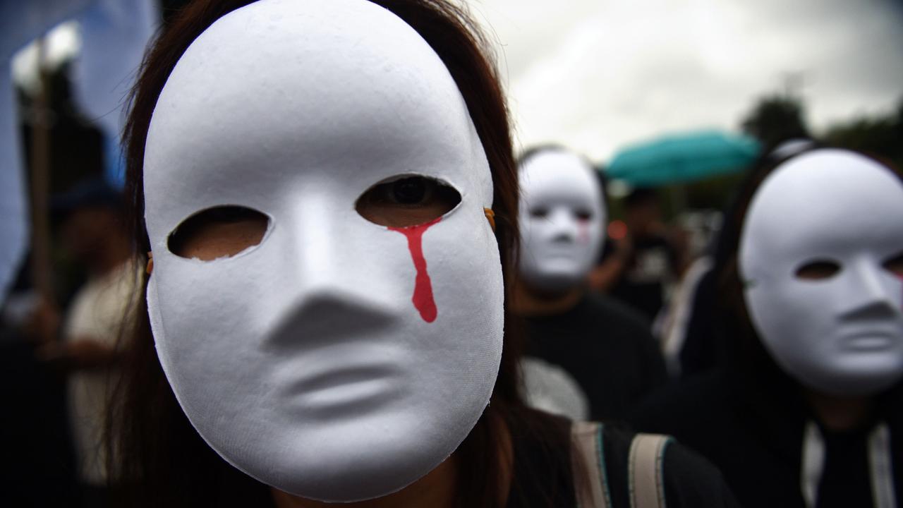 Protesters wearing masks depicting victims of extra judicial killings take part in a demonstration in Manila. Picture: Ted Aljine/AFP