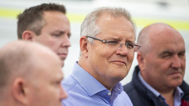 The PM, centre, pictured at The Picton Evacuation Centre in Picton. He returned to Australia from a family holiday late on Saturday, following intense criticism. Picture: Getty Images