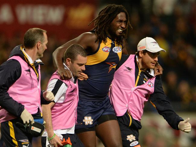 West Coast's Nic Naitanui in the hands of the trainers after hurting his knee. Picture: Daniel Wilkins