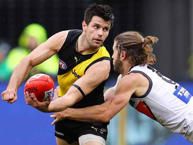 Richmond vs. GWS Giants at the MCG. Richmond's Trent Cotchin clears by hand as he is tackled by GWS Giants Callan Ward . Pic: Michael Klein