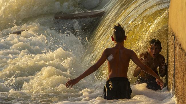 A boy is under the flow of water at Brewarrina Weir. Picture: Jenny Evans/Getty Images