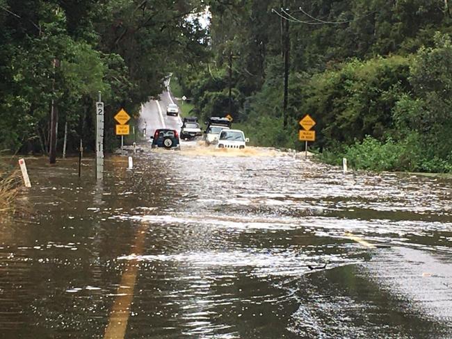 Cars driving through flood water along Yarramalong Rd. Despite the warnings people still take the chance. Picture: Yarramalong RFS.