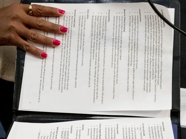 An aide to Facebook CEO Mark Zuckerberg closes a binder of notes left on the table as Zuckerberg takes a short break from testifying. Picture: AP Photo/Andrew Harnik