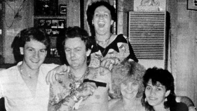 Dennis Allen playfully points a pistol at the head of his mother Kath Pettingill at a party in one of Dennis' houses.