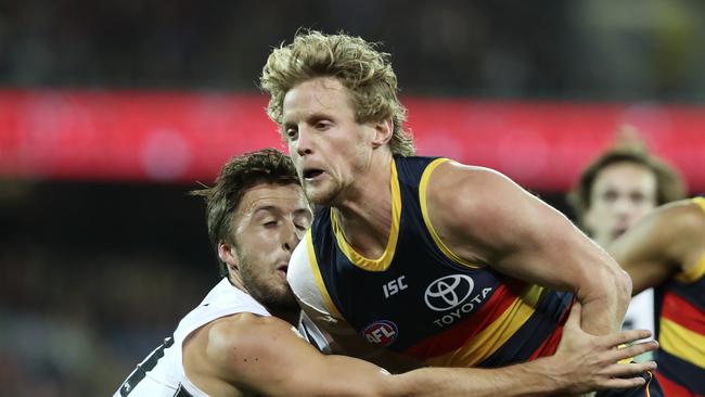 Crows Rory Sloane under pressure from Collingwood’s Tom Phillips. Picture Sarah Reed