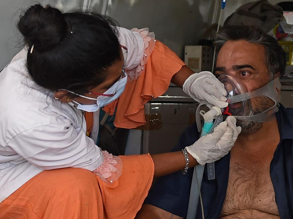 India has struggled with oxygen supply issues. Here a COVID-19 coronavirus patient on oxygen support is helped by a health worker inside an ambulance. Picture: Sam Panthaky / AFP)