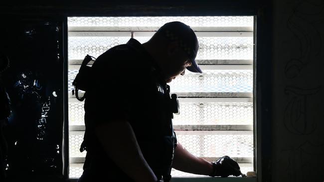 A Corrective Services officers checks the seal on a window for contraband during a raid on cells at Silverwater Jail. Picture: Richard Dobson