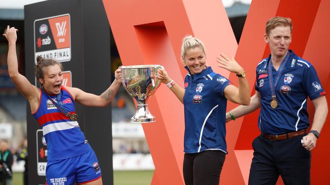 Potential returning Western Bulldogs coach Paul Groves (right) celebrates the 2018 premiership win with Ellie Blackburn (left) and Katie Brennan. Picture: Michael Willson / Getty Images