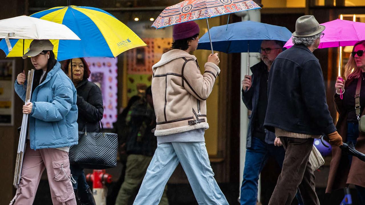 People in Adelaide hurry along with umbrellas on yet another rainy day this winter. Picture: Tom Huntley