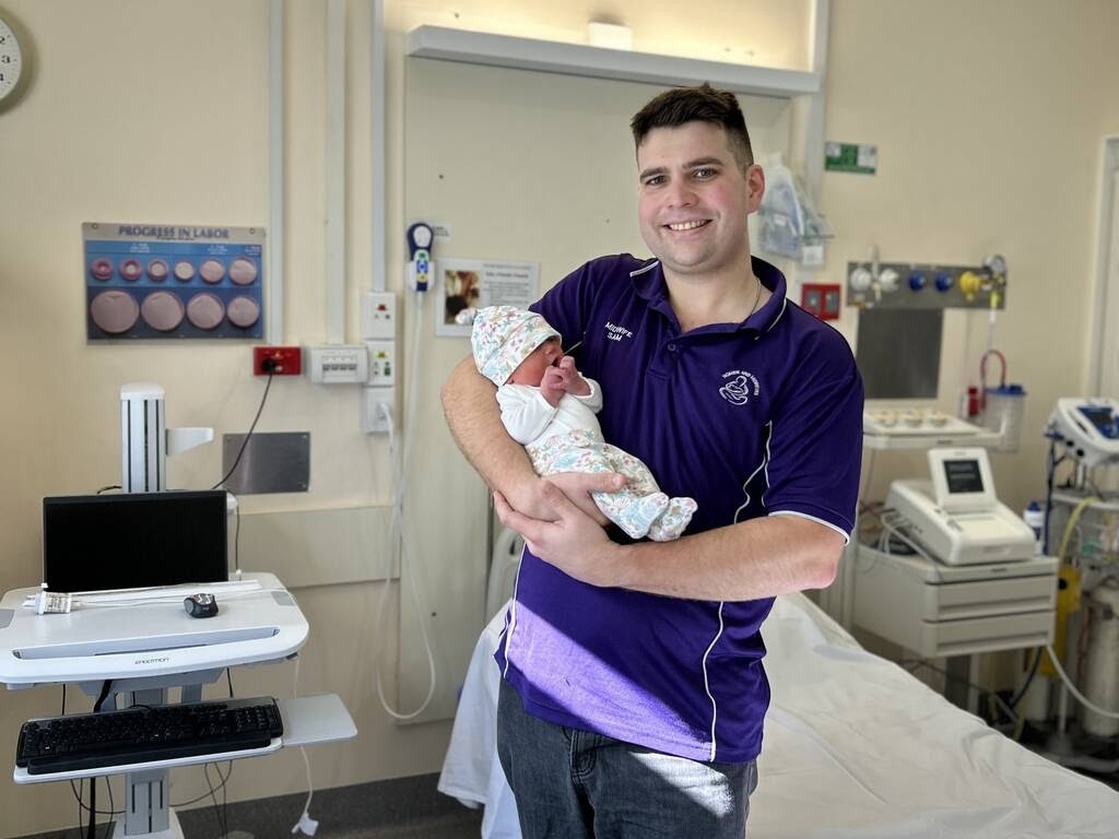 Warwick midwife Sam Gale and his newborn daughter Emmeline. Photo: DDH Media