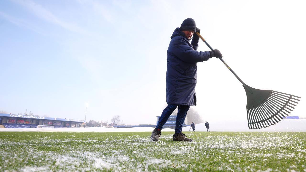 A ground staff member prepares the pitch after the covers are removed. (Photo by Clive Rose/Getty Images)