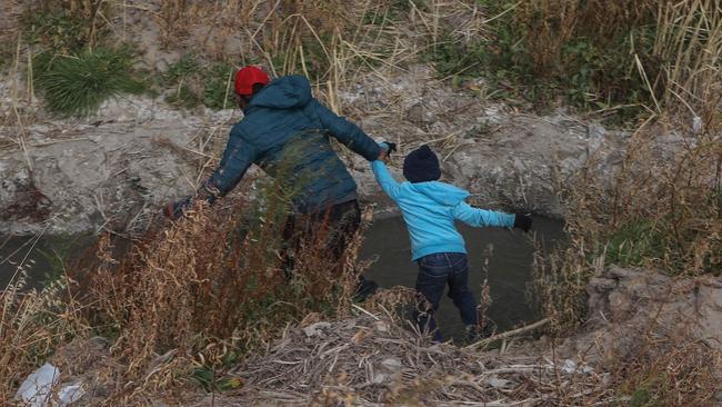 A Guatemalan migrant and his son cross the Rio Grande natural border between El Paso, Texas, and Mexico. Picture: AFP