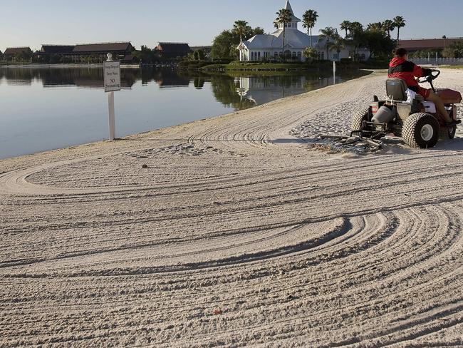 A groundsmen rakes the beaches of Disney's Grand Floridian Resort &amp; Spa at Disney World in Orlando. Picture: AFP