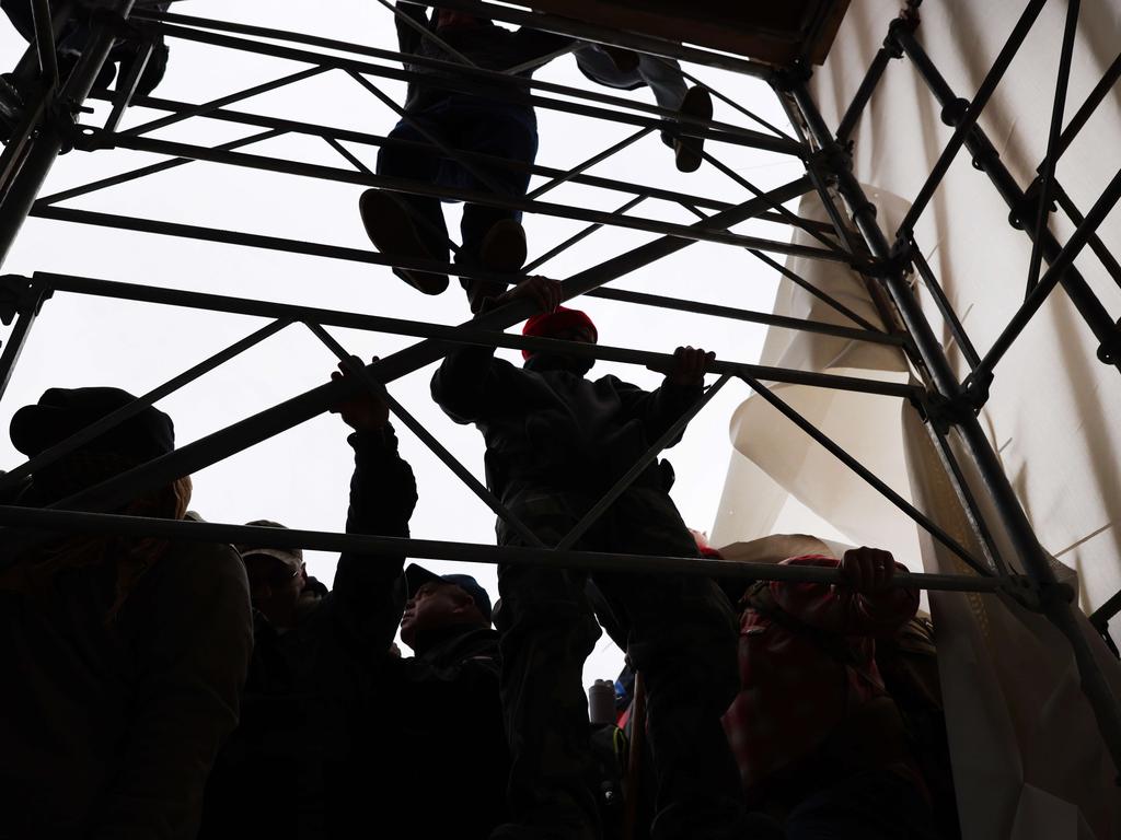 Rioters climbed scaffolding outside the US Capitol building. Picture: AFP