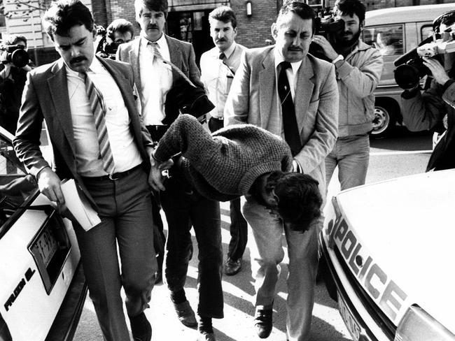 Peter Reed is escorted by police after his arrest. Picture: HWT library.