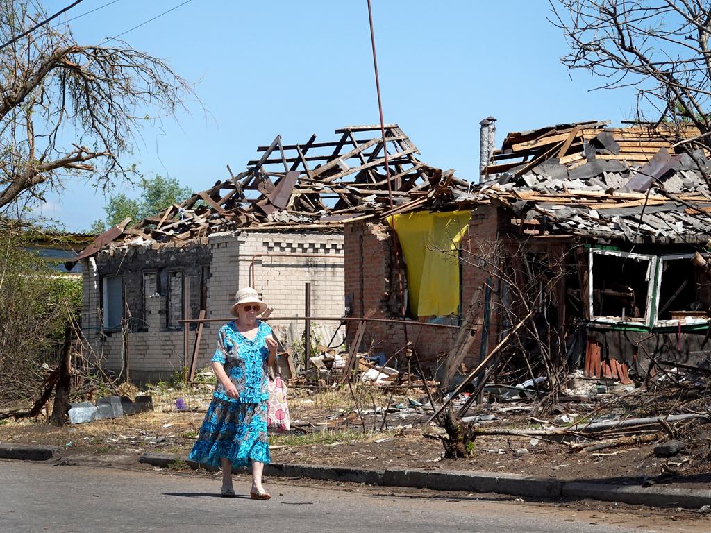 A woman takes a Sunday walk past a home that was recently damaged by a Russian missile strike in Ukraine's Donbas region. Picture: Getty Images