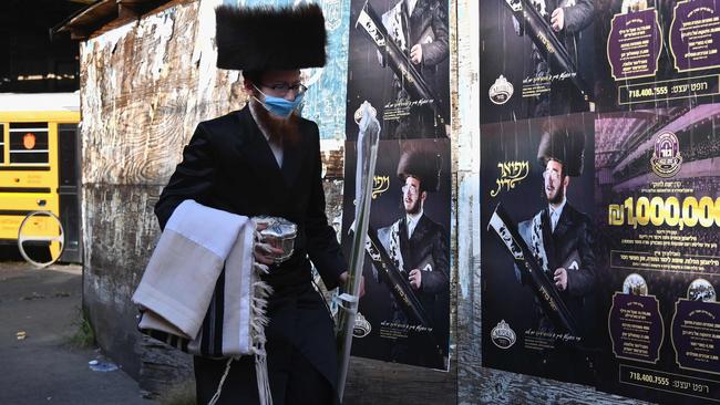 A Hasidic man with a facemask walks in the Brooklyn neighbourhood of Borough Park, Picture: AFP