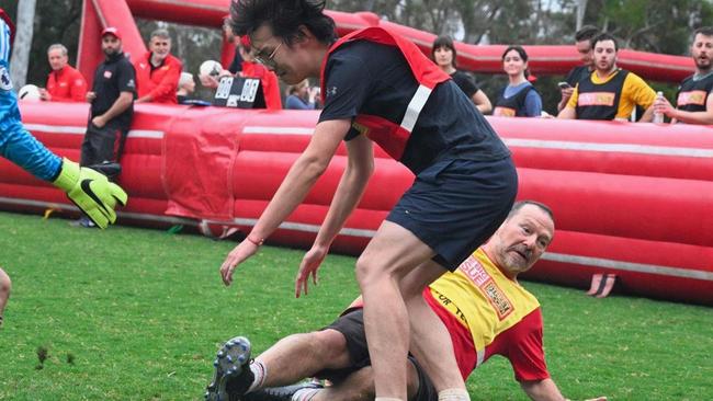 Labor MP Graham Perrett tackles an opponent at a charity match.