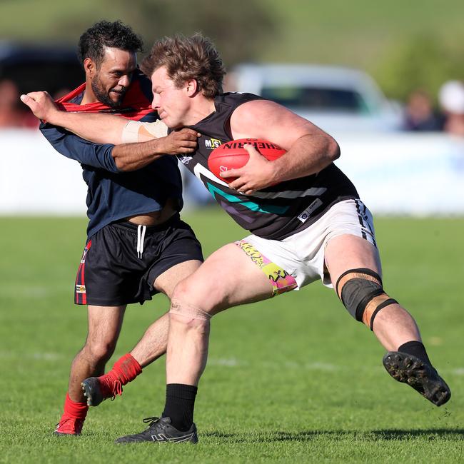 Swifts Creek’s Nathan Hayes tries to stop Omeo-Benambra’s Cody Graske. Picture Yuri Kouzmin