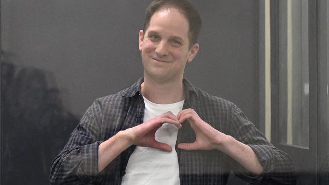 Evan Gershkovich, arrested on espionage charges, shapes a heart with his hands inside a defendants' cage after a hearing to consider an appeal on his extended pre-trial detention. Picture: AFP.