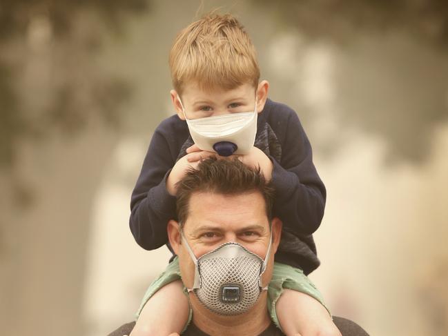 Mallacoota Fires.  Kane Hartrup and his son Cole 4, wearing masks due to the heavy smoke.           Picture: David Caird