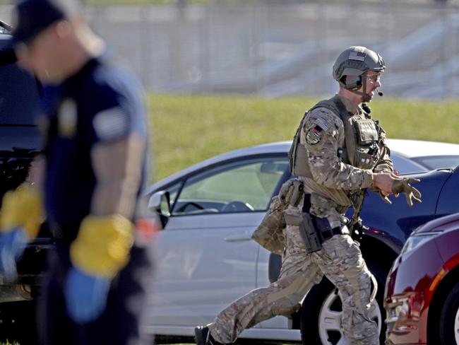 A SWAT team officer rushes toward Marjory Stoneman Douglas High School. Police were quickly given a good idea of who they were after by students and teachers via social media. Picture: AP