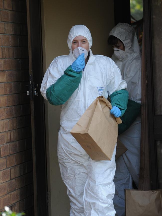 A police officer in protective clothing leaves the Parafield Gardens house.