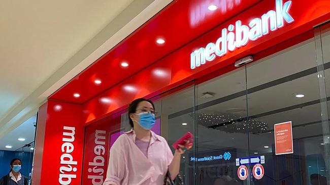People walk past a shop front for Australia's largest health insurance company Medibank. Picture: Muhammad Farooq/AFP