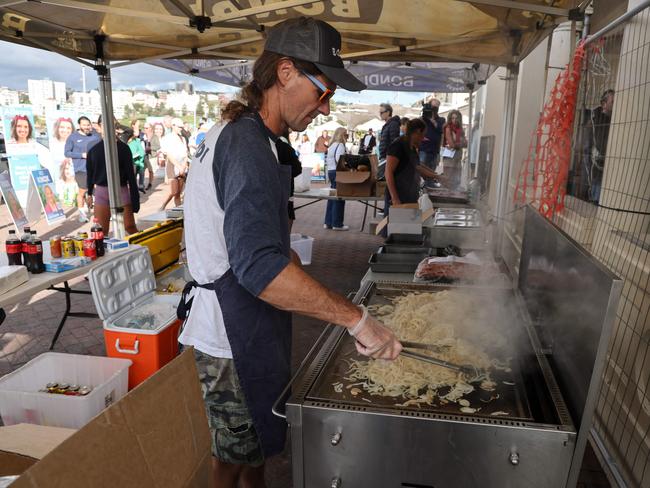 There’s also nothing more Aussie than a man with a mullet grilling sausages and onions on election morning. (Photo by DAVID GRAY / AFP)