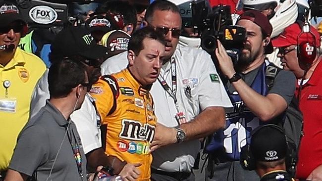 Kyle Busch is escorted away by a NASCAR official after an incident on pit road with Joey Logano (not pictured).