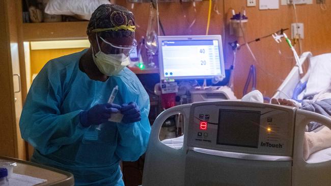 A medical worker in full PPE works on a patient who has Covid-19 in a negative pressure room in ICU. Picture: Joseph Prezioso