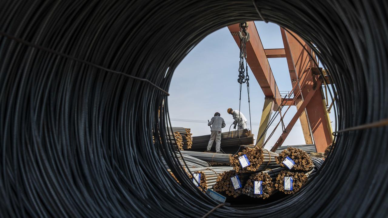 Workers prepare to lift a bundle of steel reinforcing bar with a gantry crane at a metal stock yard in Shanghai, China. Picture: Qilai Shen/Bloomberg