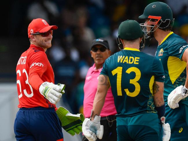 England's captain Jos Buttler (L) talks to Australia's Matthew Wade during the ICC men's Twenty20 World Cup 2024 group B cricket match between Australia and England at Kensington Oval in Bridgetown, Barbados, on June 8, 2024. (Photo by Randy Brooks / AFP)