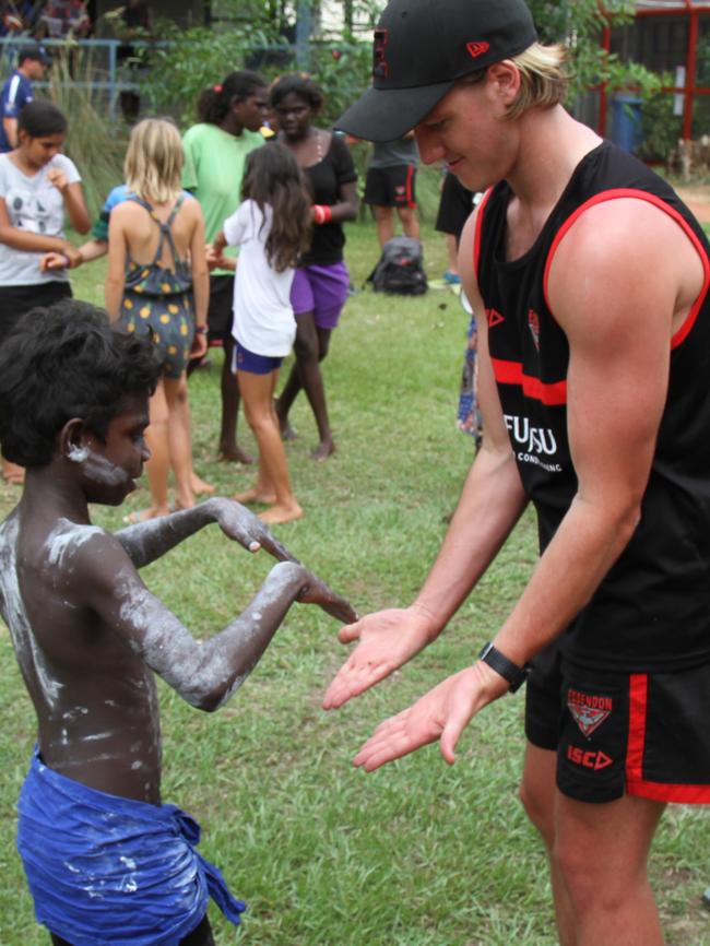 Darcy Parish low fives a student at Maningrida. Picture: NATALIE MacGREGOR