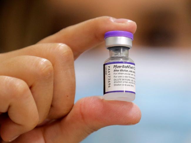 A health worker shows a vial of the Pfizer-BioNTech Covid vaccine. Picture: Javier Torres / AFP.