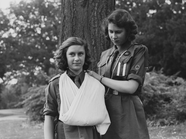 Princess Elizabeth places Princess Margaret’s arm in a sling as part of the Girl Guides in Frogmore, Windsor. Picture: Getty