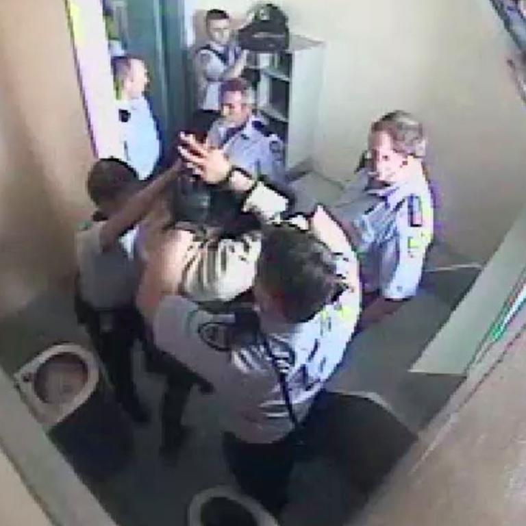 CCTV footage from Brisbane Correctional Centre of a 17-year-old having restraints and a spit hood put on him.